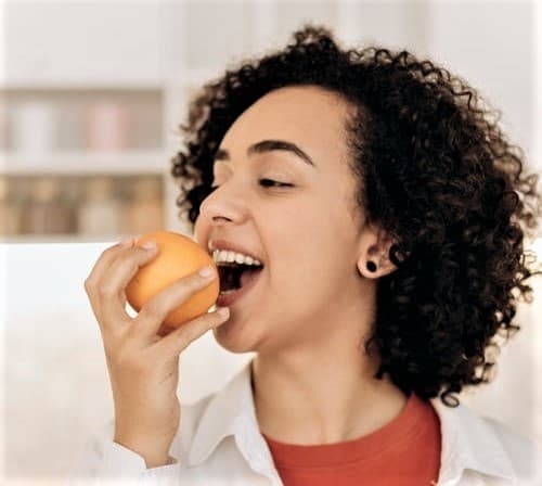 woman eating orange
