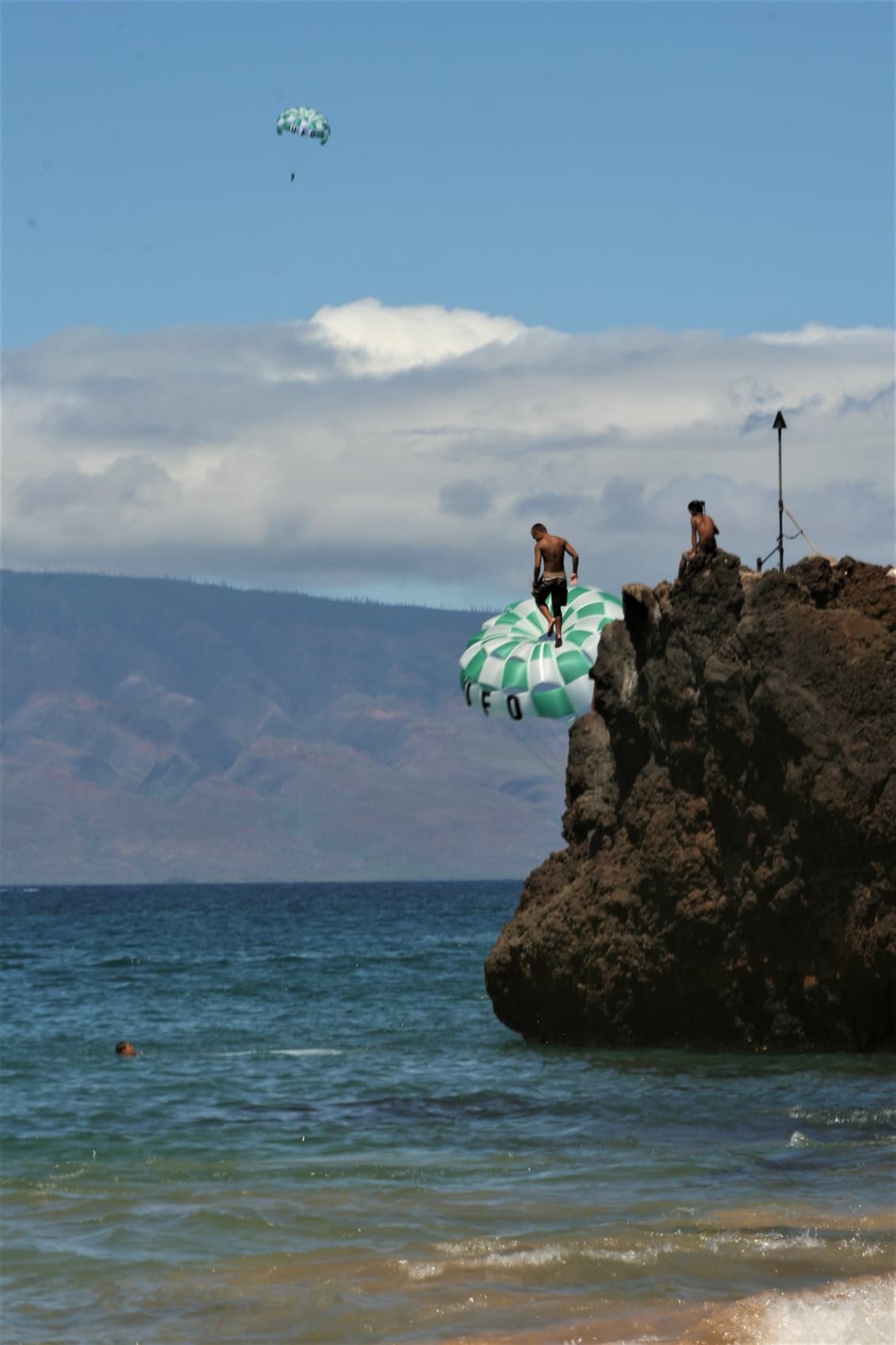 Jumping off rock into water, Maui Black Rock Beach